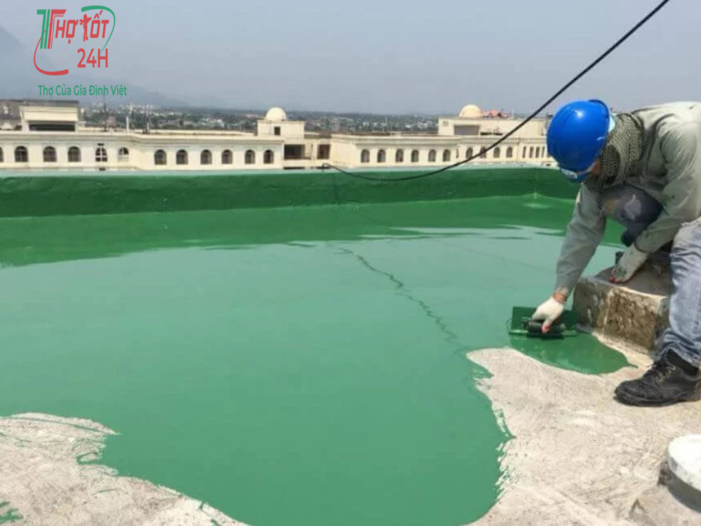 Thợ thi công lăn sơn chống thấm màu xanh bảo vệ sàn mái bê tông