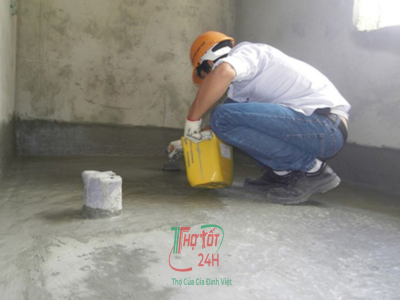 Thợ thi công đang quét vật liệu chống thấm nhà vệ sinh bằng màng chống thấm gốc xi măng chuyên dụng