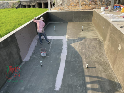 Thợ thi công quét phủ lớp vật liệu chống thấm tầng hầm và xử lý mạch ngừng bê tông