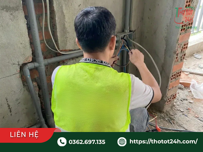 Thợ điện mặc áo phản quang đang khảo sát và đấu nối dây điện công trình theo giá sửa điện nước.