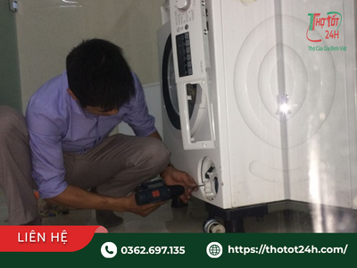 Kỹ thuật viên đang kiểm tra cân chỉnh chân đế và lò xo giảm chấn khắc phục máy giặt bị rung lắc mạnh