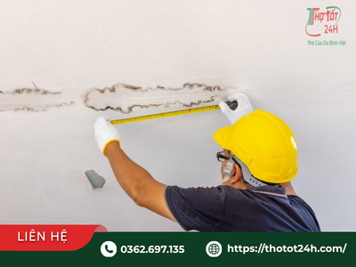 Thợ kiểm tra vết nứt trần nhà bị dột để đánh giá mức độ an toàn kết cấu.