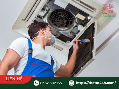 Nhân viên kỹ thuật cẩn thận làm sạch bụi bẩn quạt gió trong quá trình vệ sinh máy lạnh văn phòng âm trần.