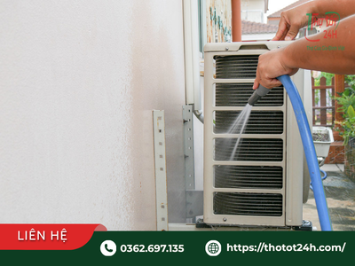 Thợ kỹ thuật xịt rửa dàn nóng ngoài trời trong quy trình vệ sinh máy lạnh văn phòng định kỳ cho doanh nghiệp.